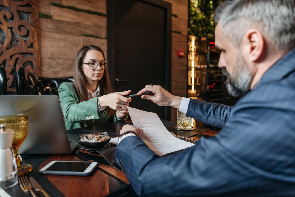 Man Handing a Pen to the Woman