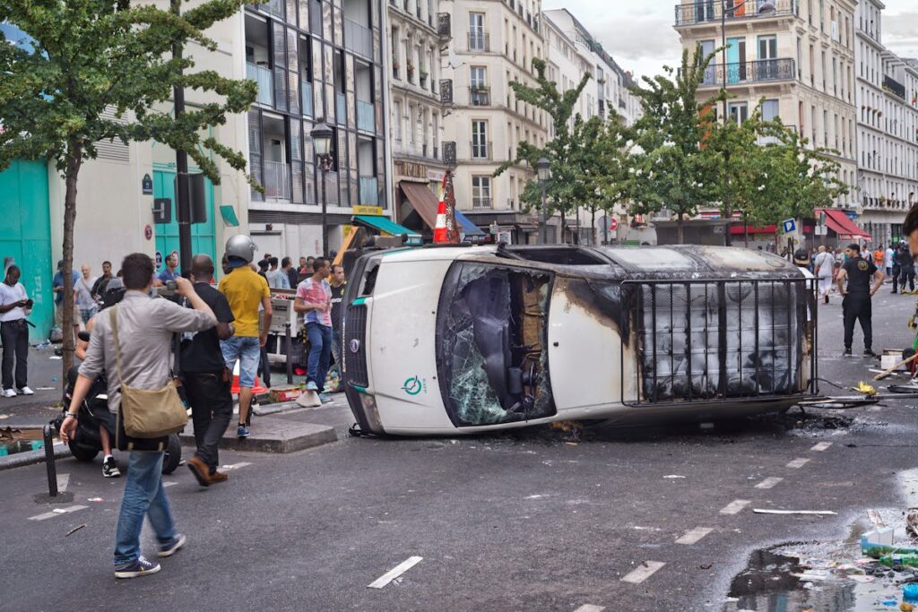 People around Destroyed Car on Street