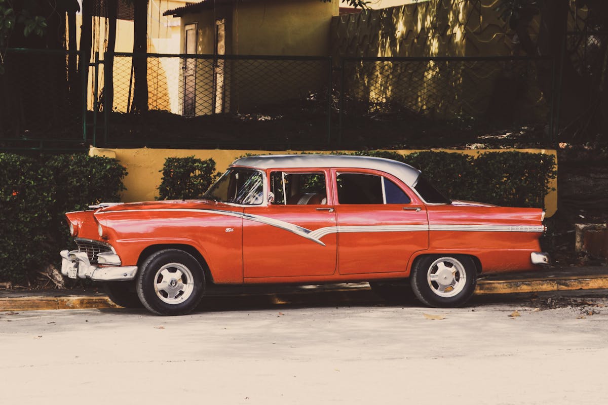 Red Sedan Parked Beside a Sidewalk