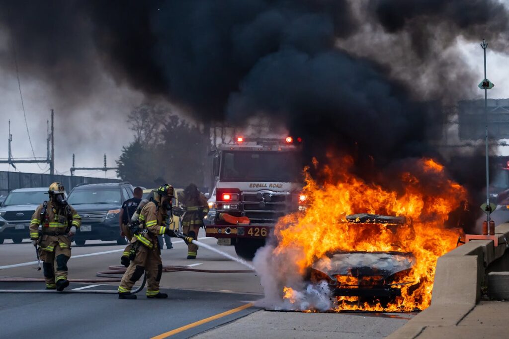 Firefighters Putting Down Flaming Car