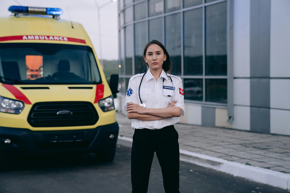 Paramedic Standing with Arms Crossed by Ambulance