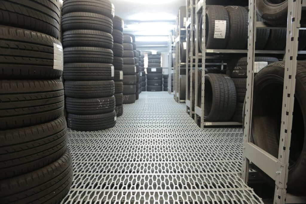 Rows of stacked tires in an indoor industrial warehouse for storage.