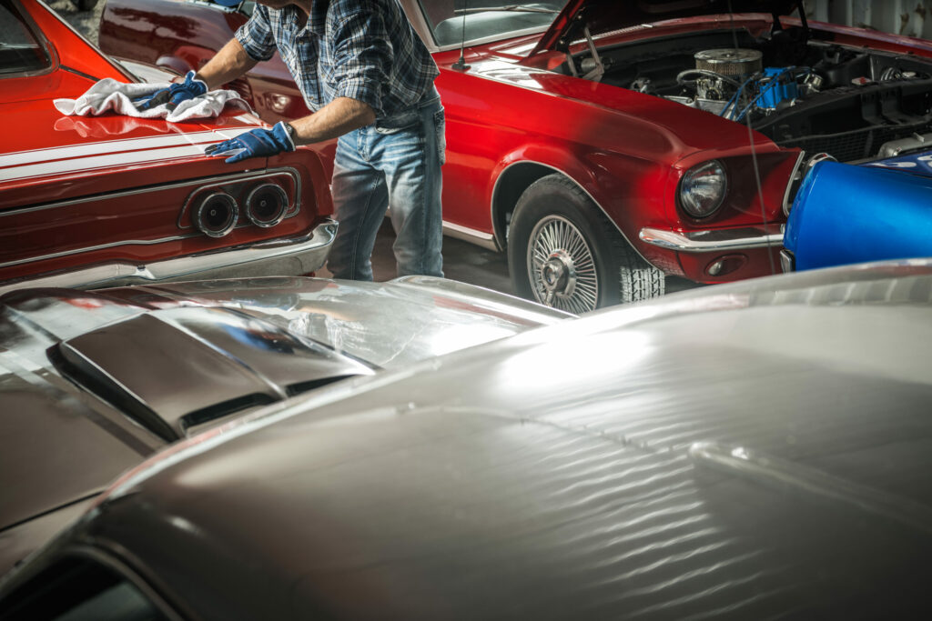 American Classic Cars Collection Owner Cleaning His Dream Cars Inside a Shop.